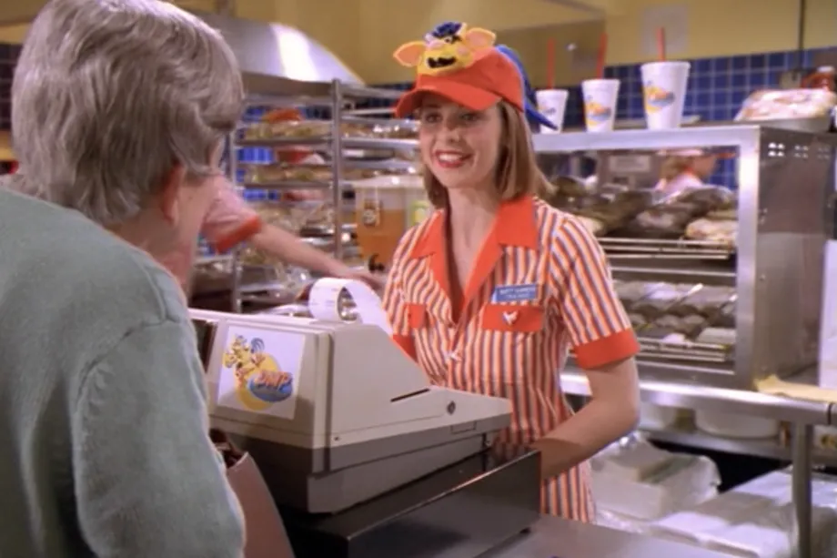 A woman serving a man in a fast food restaurant.