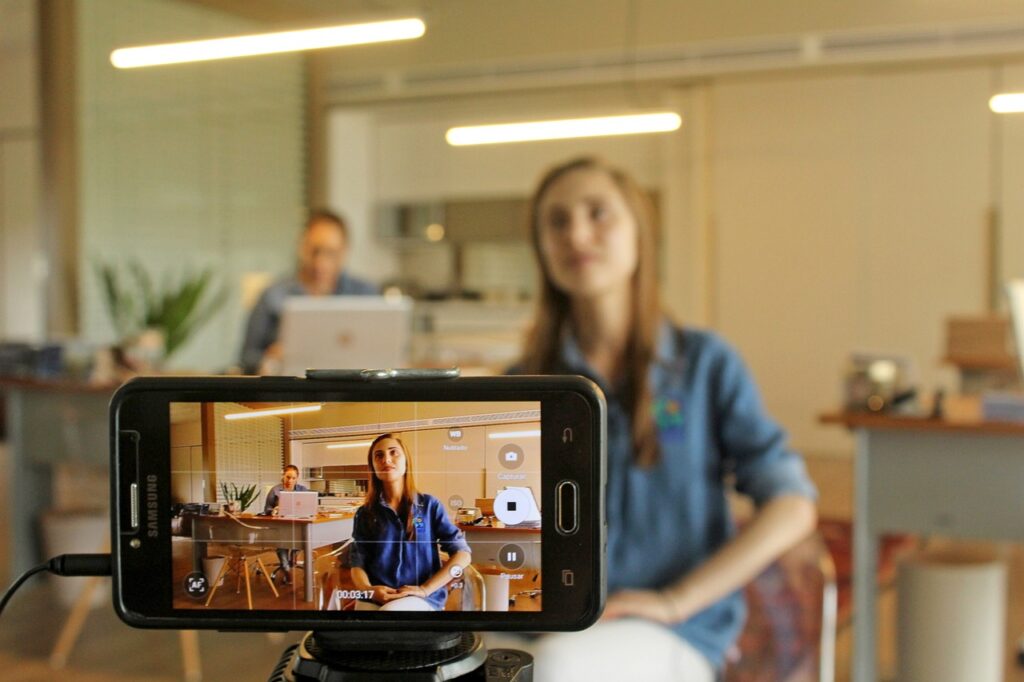 A woman being filmed on a smartphone