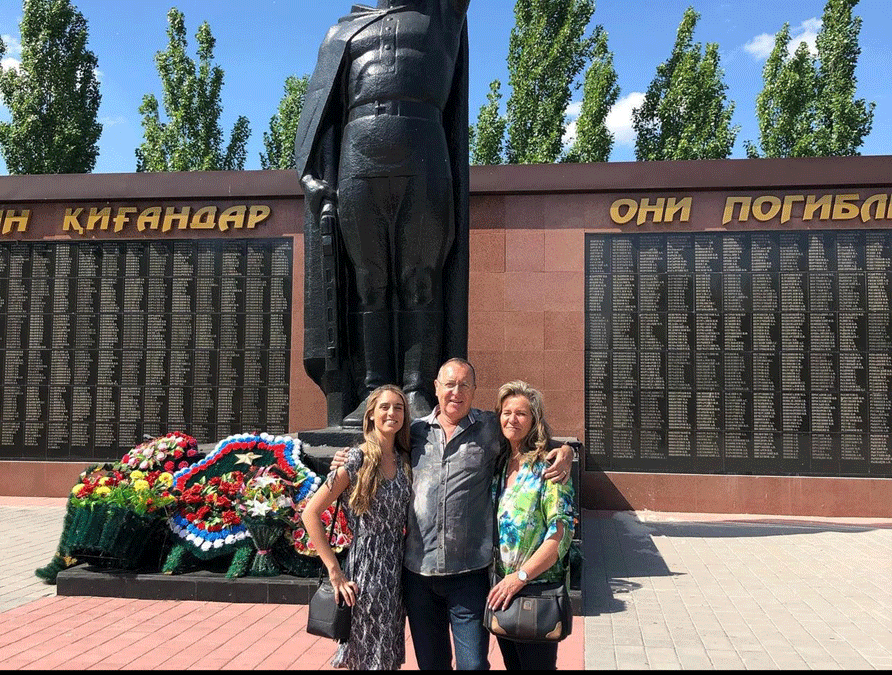A photo of two women and a man in front of a monument