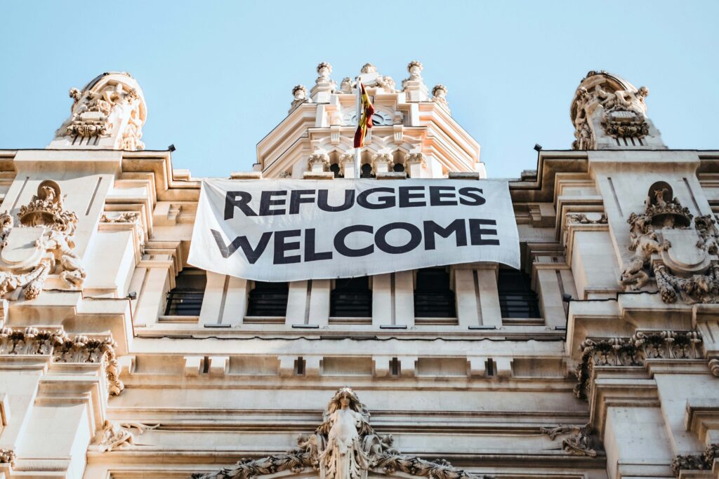 Picture of a buildng with 'Welcome Refugees' sign