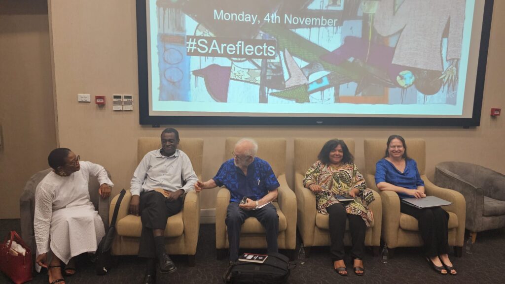 Panellists at a conference sitting on chairs 