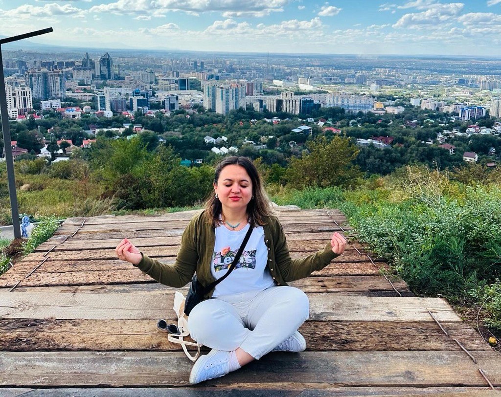 Woman doing yoga in top of a hill